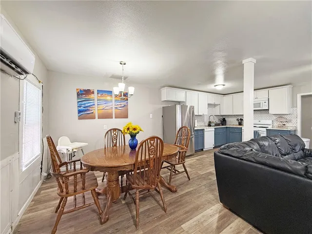 a living room with furniture kitchen view and a wooden floor