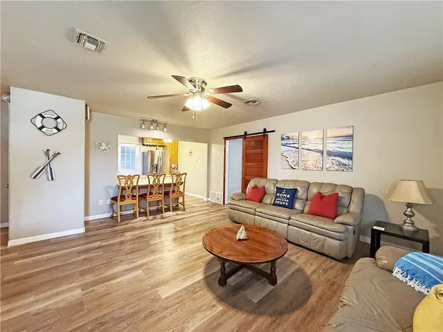 a living room with furniture and wooden floor