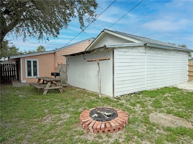 a backyard of a house with table and chairs