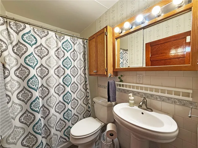 a bathroom with a toilet a sink and mirror