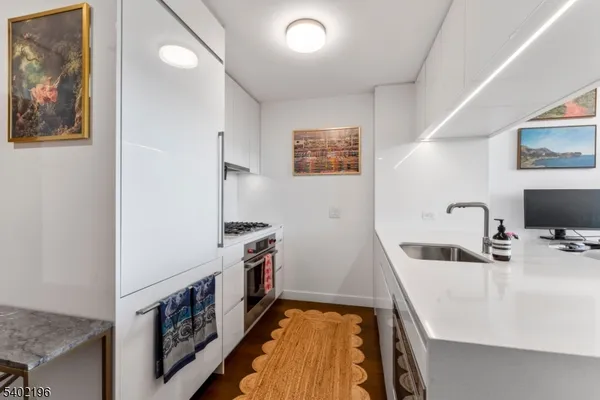a view of a kitchen with a sink and a refrigerator