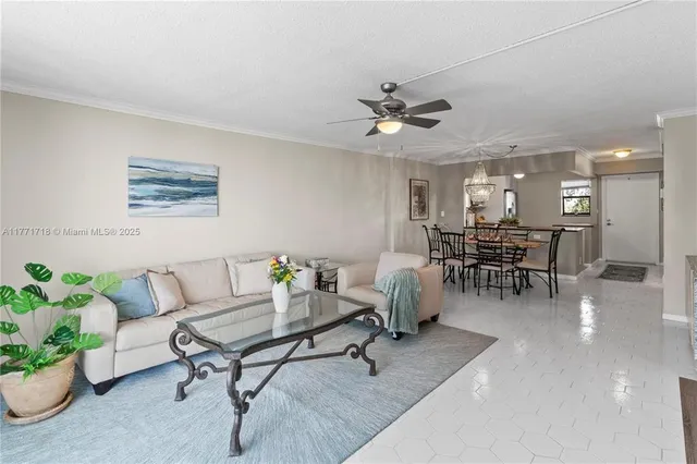 a living room with furniture and a dining table with kitchen view