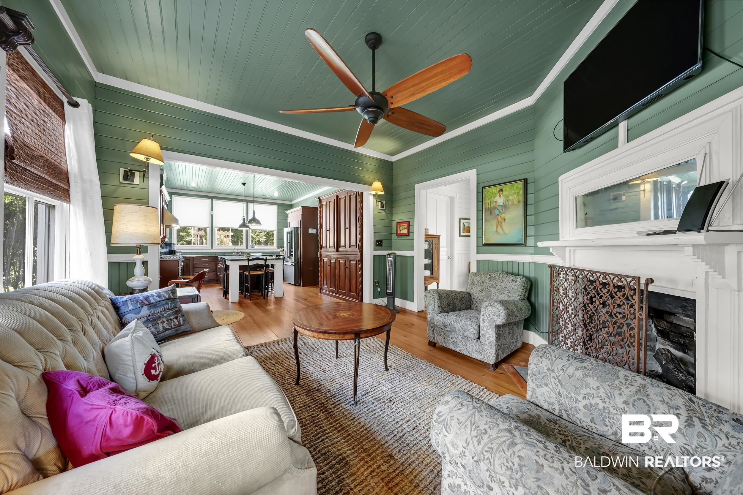 13232 Mary Ann Bch Road Fairhope, AL 36532 - Photo 12 of 79 Living room featuring a fireplace, wood walls, wood finished floors, wooden ceiling, and ceiling fan