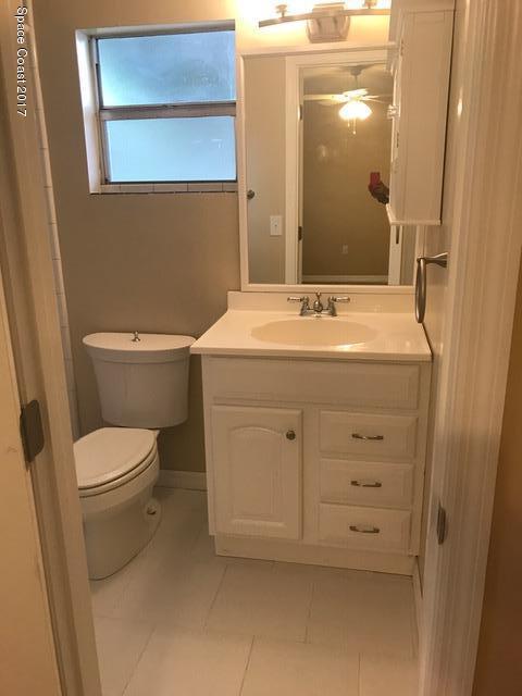 3685 Longbow Road Cocoa, FL 32926 - Photo 7 of 17 a bathroom with a granite countertop toilet sink and mirror