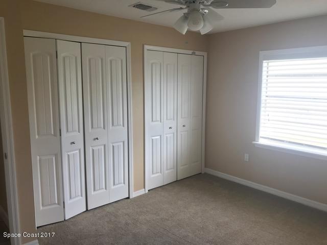 3685 Longbow Road Cocoa, FL 32926 - Photo 10 of 17 an empty room with chandelier fan and windows