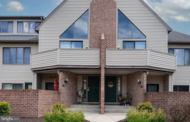 a view of a house with large windows and plants