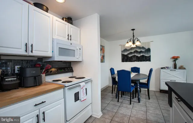 a kitchen with granite countertop white cabinets and appliances