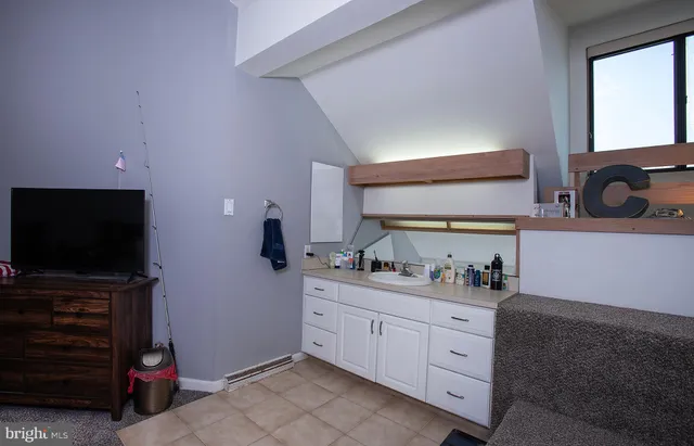 a bedroom with a bed and a flat tv screen on dresser
