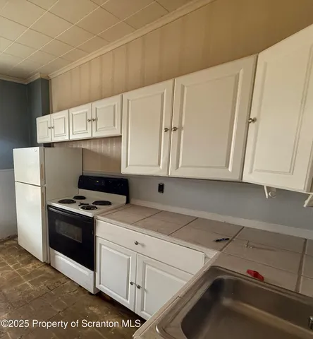 a kitchen with white cabinets and white appliances