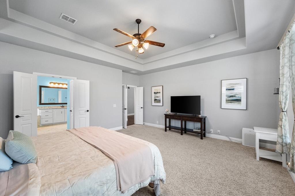 7235 Neblina Drive Grand Prairie, TX 75054 - Photo 16 of 32 a bedroom with a bed and a chandelier