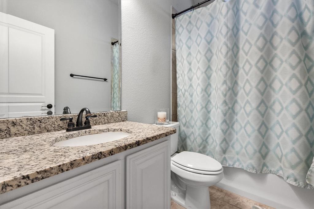 7235 Neblina Drive Grand Prairie, TX 75054 - Photo 22 of 32 a bathroom with a granite countertop sink and a mirror