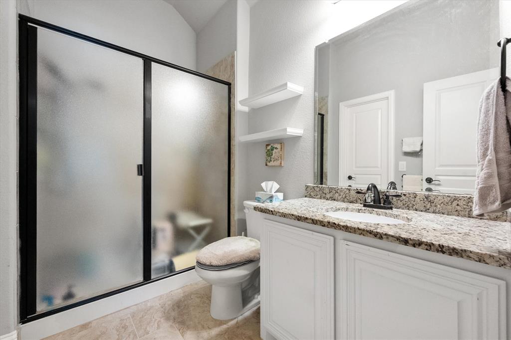 7235 Neblina Drive Grand Prairie, TX 75054 - Photo 29 of 32 a bathroom with a granite countertop sink and a mirror