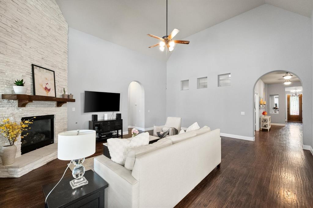 7235 Neblina Drive Grand Prairie, TX 75054 - Photo 7 of 32 a living room with furniture a fireplace and a flat screen tv