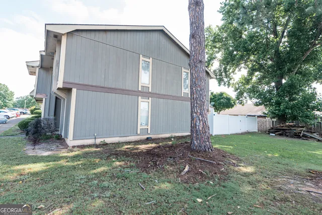 a view of a house with backyard and trees