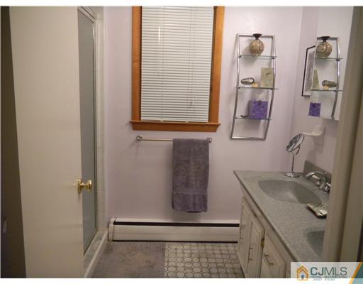 11 Devon Road Edison, NJ 08820 - Photo 20 of 23 a bathroom with a sink a mirror and shower