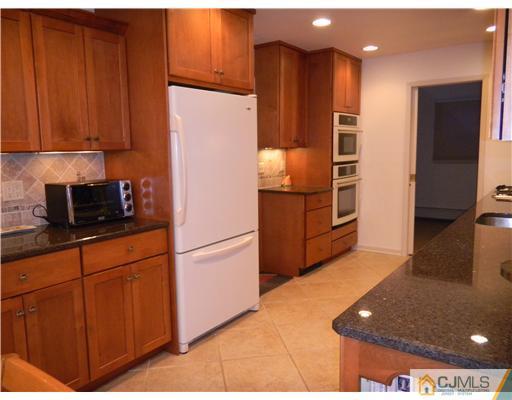11 Devon Road Edison, NJ 08820 - Photo 7 of 23 a kitchen with stainless steel appliances granite countertop a refrigerator sink and cabinets