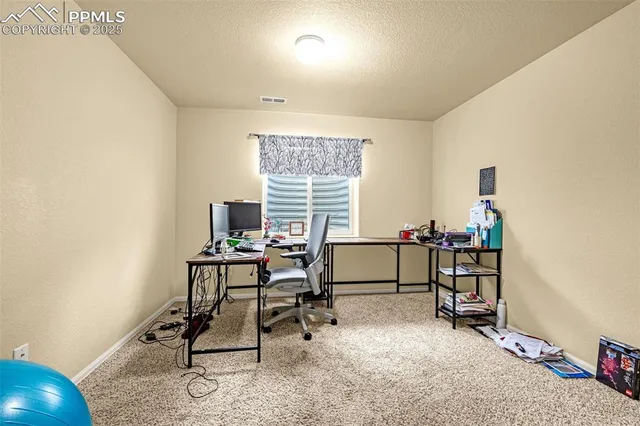 a view of a workspace with furniture and a window