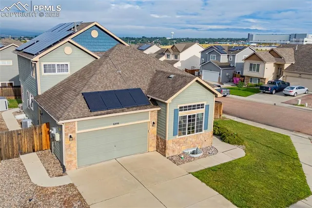 a view of a house with a yard and potted plants