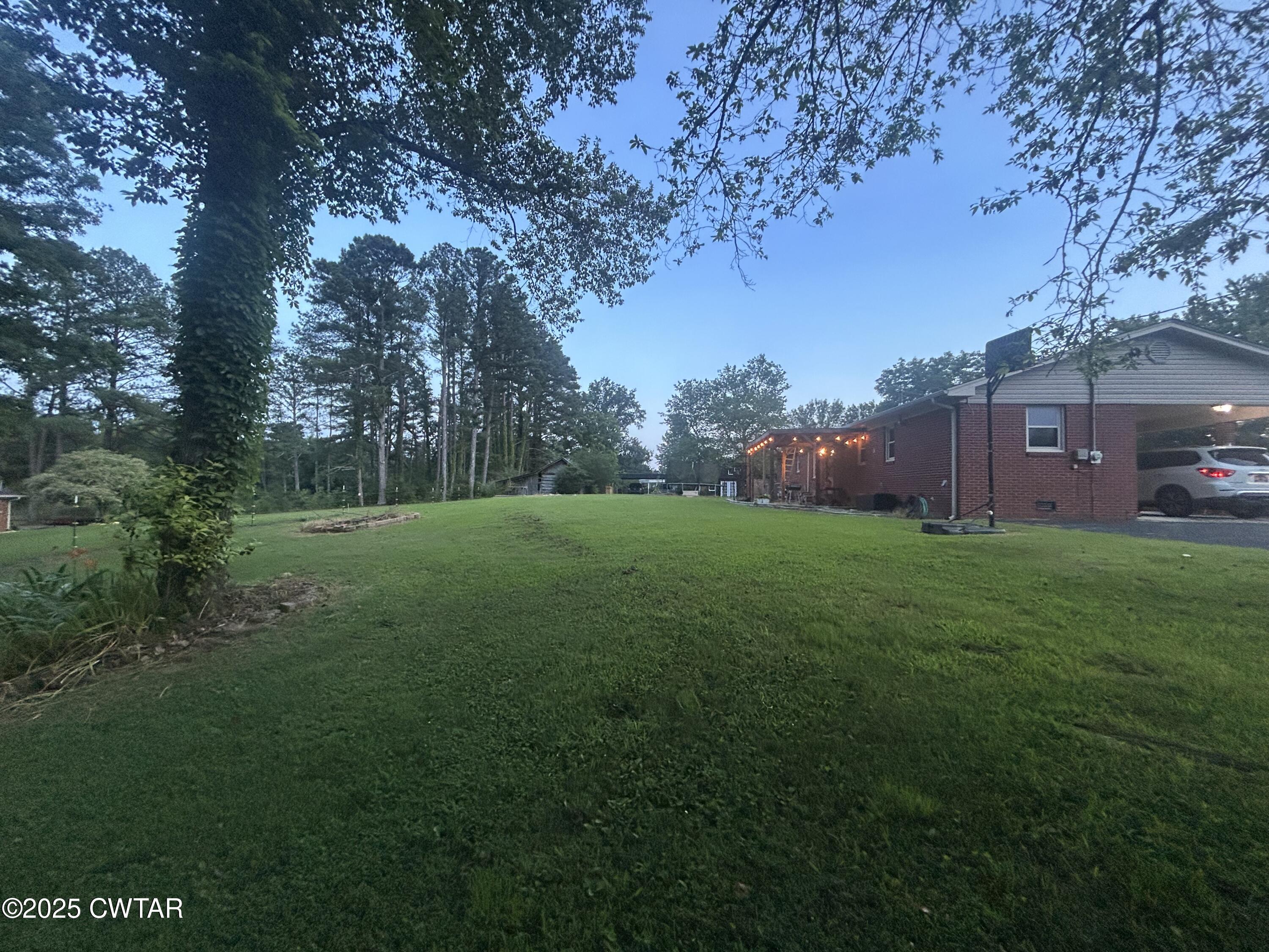 725 East Poplar Drive Decaturville, TN 38329 - Photo 2 of 43 a view of a garden with large trees