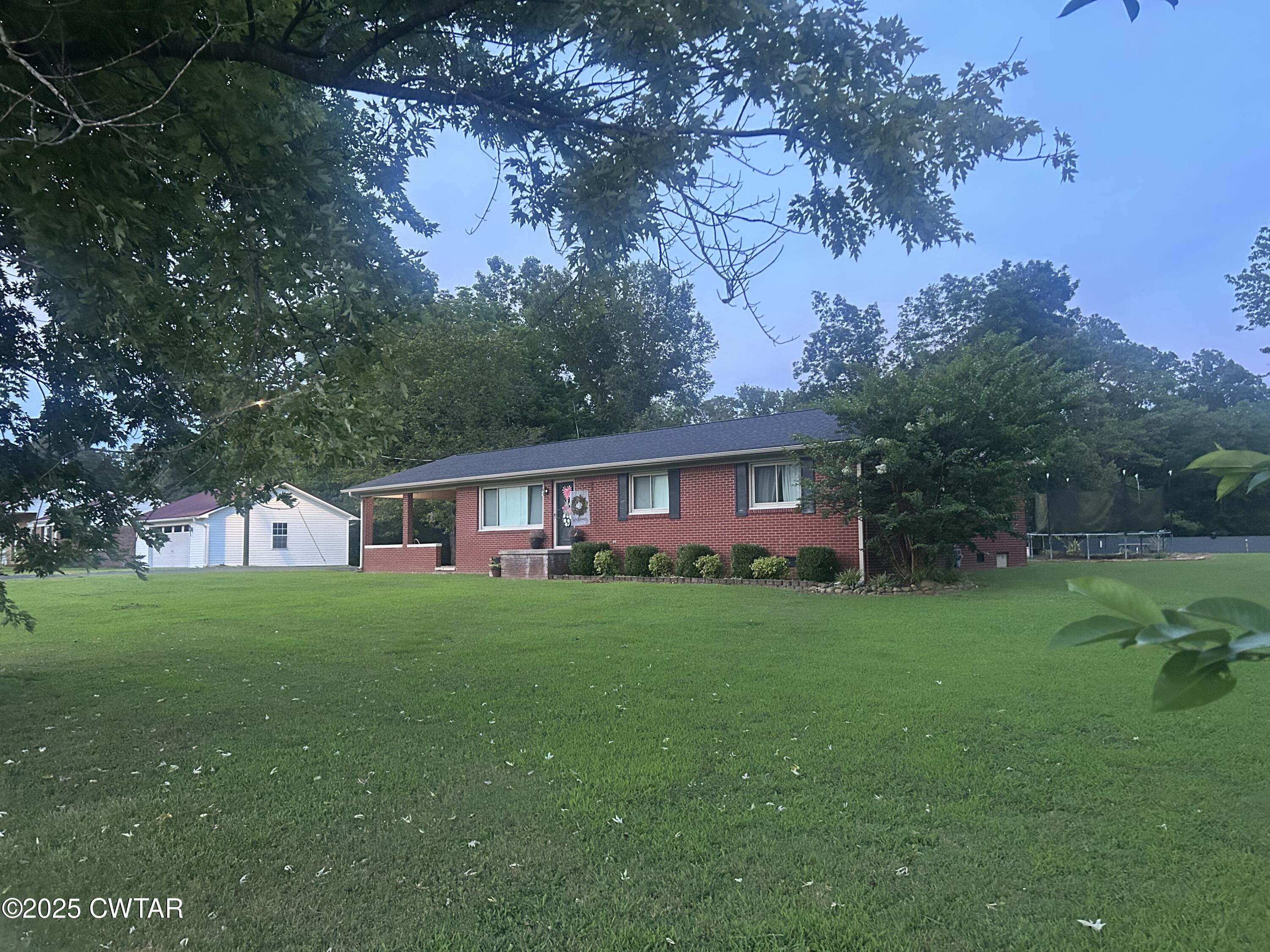 725 East Poplar Drive Decaturville, TN 38329 - Photo 41 of 43 a view of a yard in front of a house with large trees