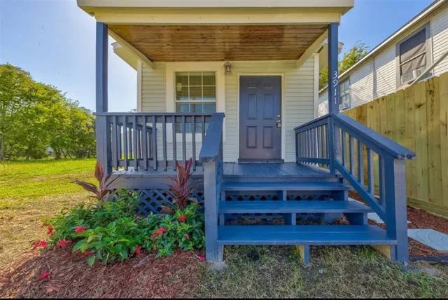 a view of a house with wooden deck and a yard