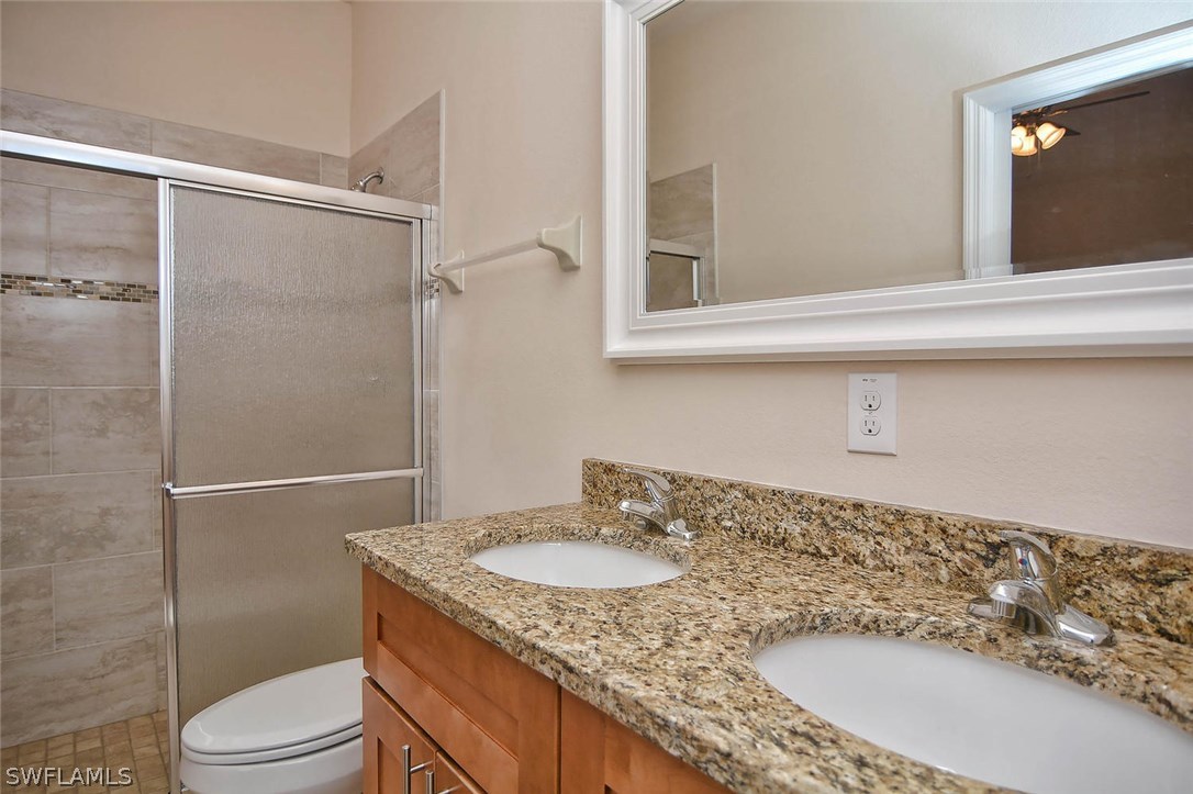18632 Holly Road Fort Myers, FL 33967 - Photo 13 of 16 a bathroom with a granite countertop sink toilet and shower