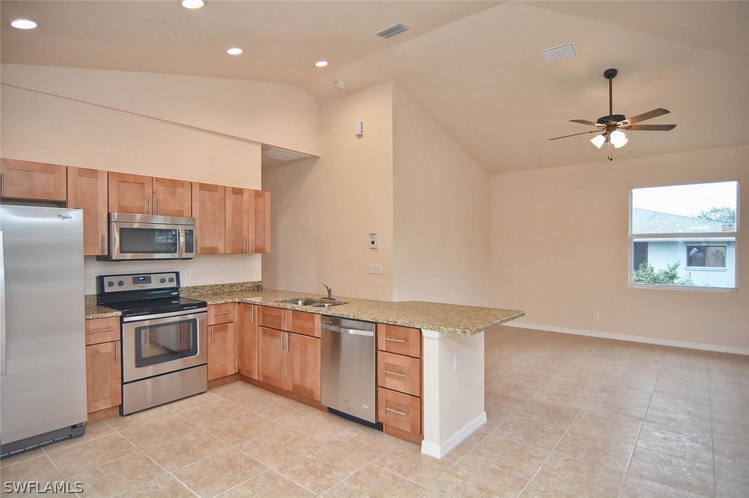 18632 Holly Road Fort Myers, FL 33967 - Photo 4 of 16 a kitchen with stainless steel appliances a sink stove and refrigerator
