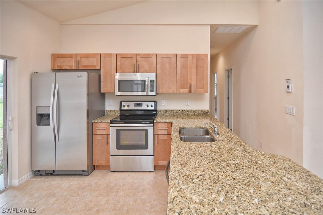 18632 Holly Road Fort Myers, FL 33967 - Photo 5 of 16 a kitchen with stainless steel appliances granite countertop a refrigerator a stove and a sink