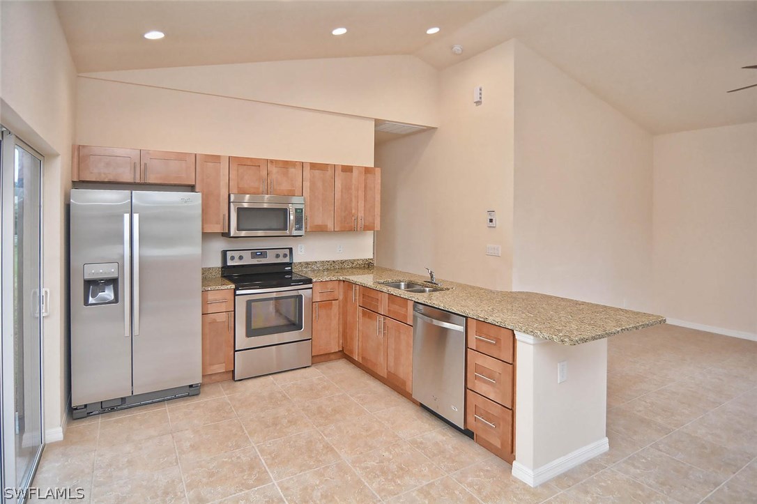 18632 Holly Road Fort Myers, FL 33967 - Photo 6 of 16 a kitchen with stainless steel appliances granite countertop a refrigerator and a stove