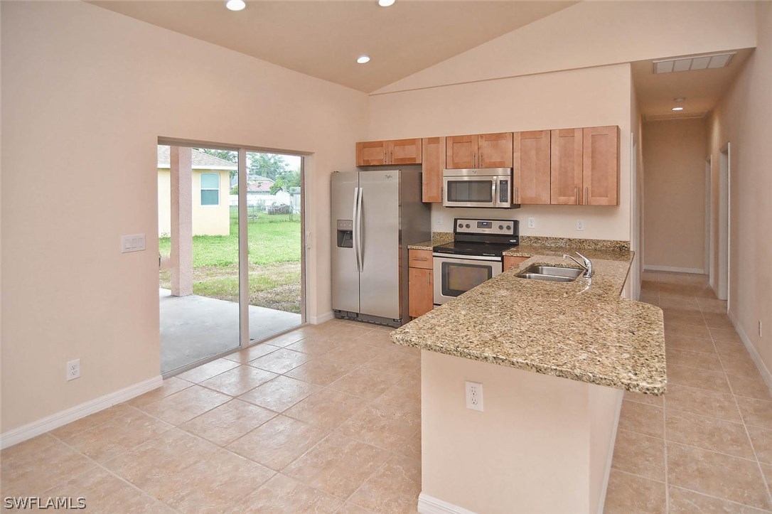 18632 Holly Road Fort Myers, FL 33967 - Photo 10 of 16 a kitchen with stainless steel appliances granite countertop a refrigerator and a sink