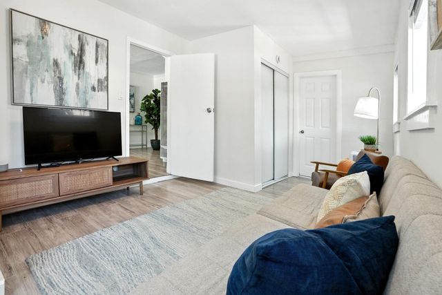 a bedroom with furniture and a flat screen tv