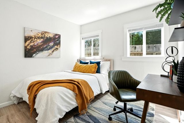 a bedroom with a bed and a table with potted plant