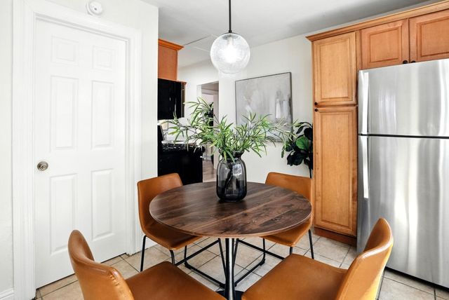 a dining room with furniture potted plants and wooden floor