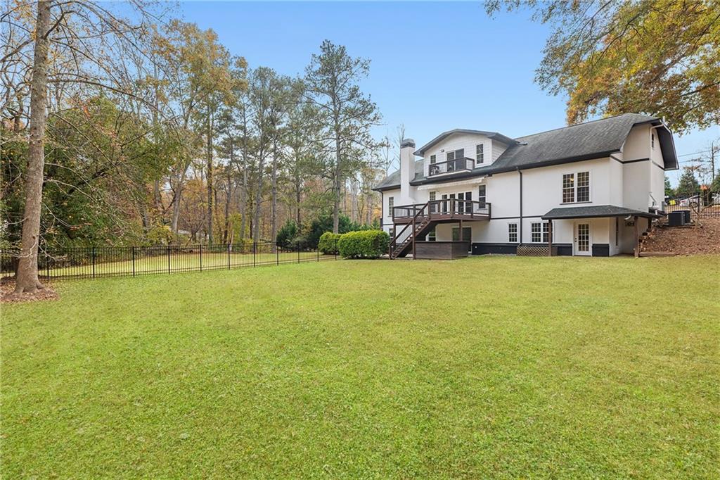 14440 Cogburn Road Alpharetta, GA 30004 - Photo 8 of 62 a view of a house with a big yard and large trees