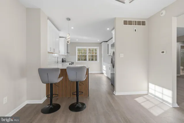 a view of a kitchen area with furniture and wooden floor