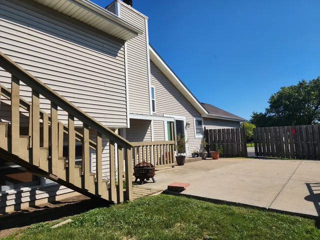 a backyard of a house with table and chairs