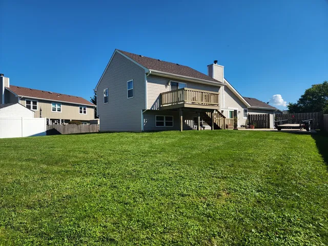 a view of a house with a yard and a large tree