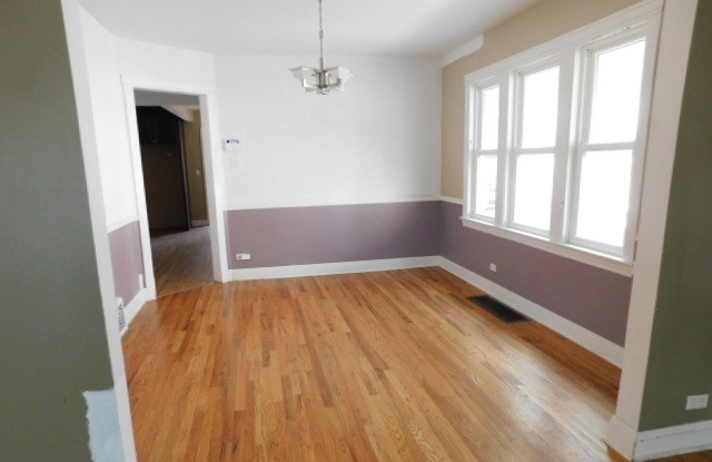 Undisclosed Address Chicago, IL 60630 - Photo 3 of 16 an empty room with wooden floor and windows