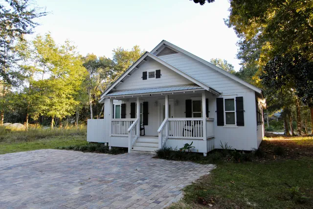 a front view of a house with a garden and trees