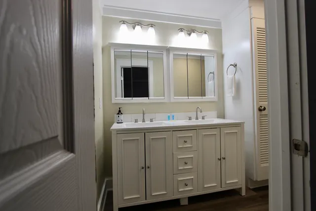a bathroom with a granite countertop sink vanity and mirror
