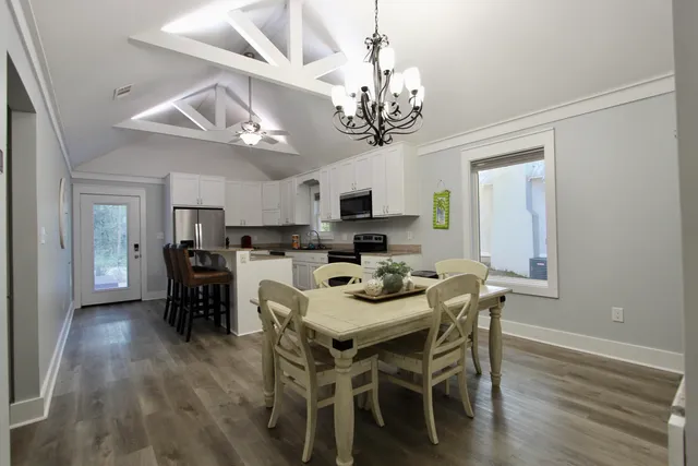 a view of a dining room with furniture wooden floor and chandelier