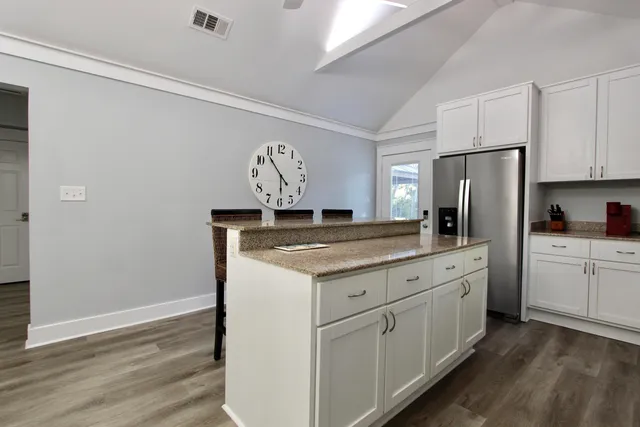a kitchen with stainless steel appliances granite countertop a refrigerator and a stove