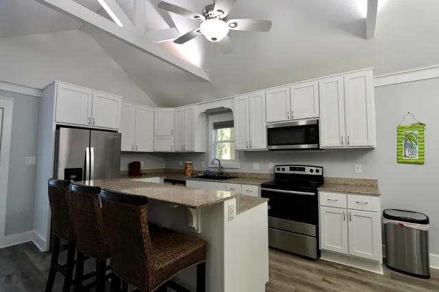 a kitchen with stainless steel appliances a stove refrigerator sink and cabinets