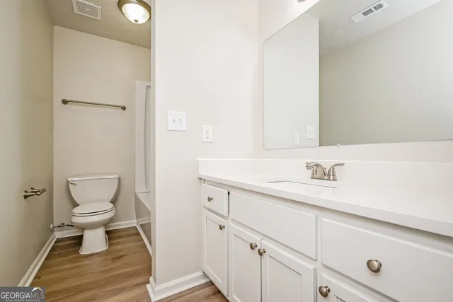 a bathroom with a sink a toilet and a mirror
