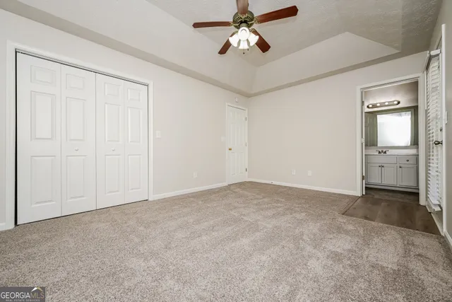 an empty room with a ceiling fan and a bathroom