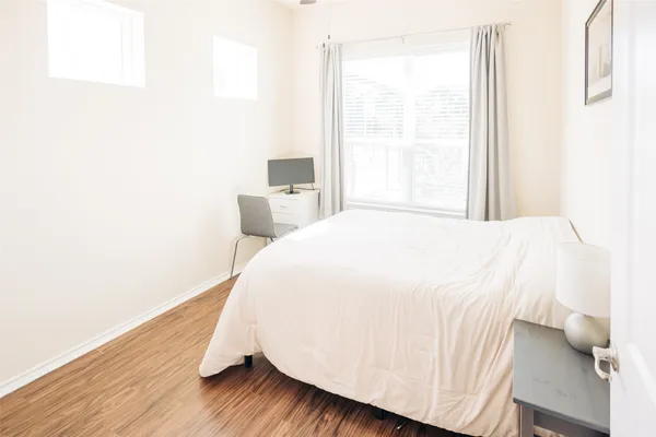 a bedroom with a bed and wooden floor