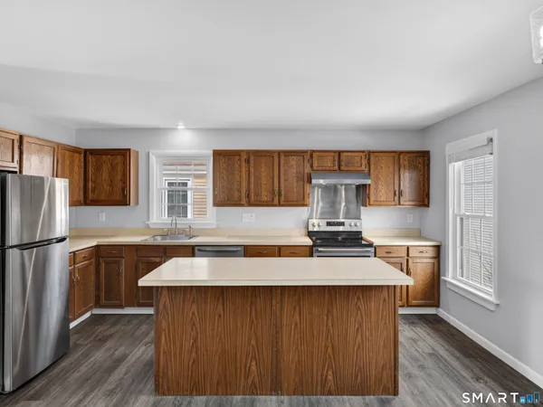 a kitchen with kitchen island granite countertop a sink stove and refrigerator