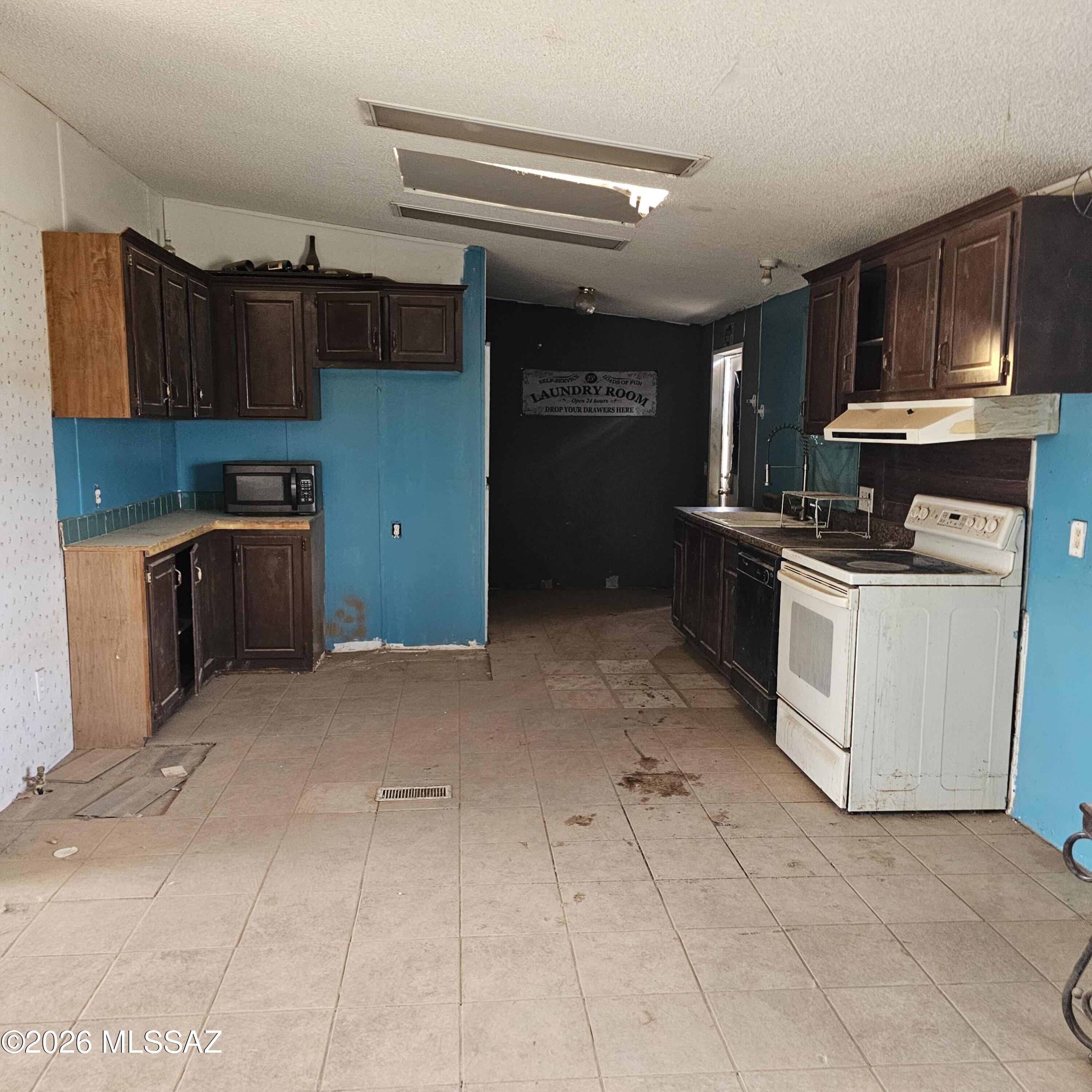 14020 West Park Road Tucson, AZ 85735 - Photo 3 of 18 a kitchen with cabinets and steel stainless steel appliances