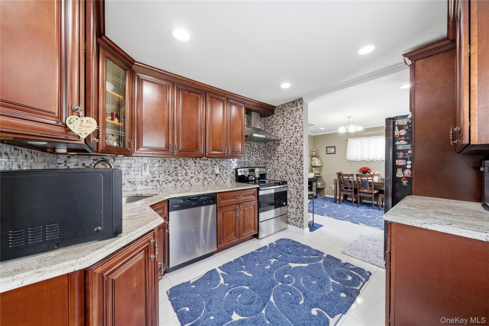 50 Ridge Lane Levittown, NY 11756 - Photo 10 of 27 a kitchen with stainless steel appliances granite countertop a sink stove and refrigerator
