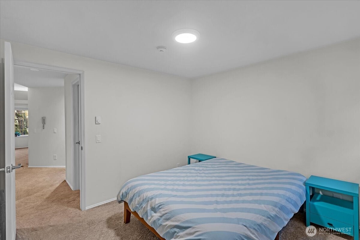 8653 Avondale Road Northeast, Unit D208 Redmond, WA 98052 - Photo 22 of 32 a bedroom with a bed and hallway